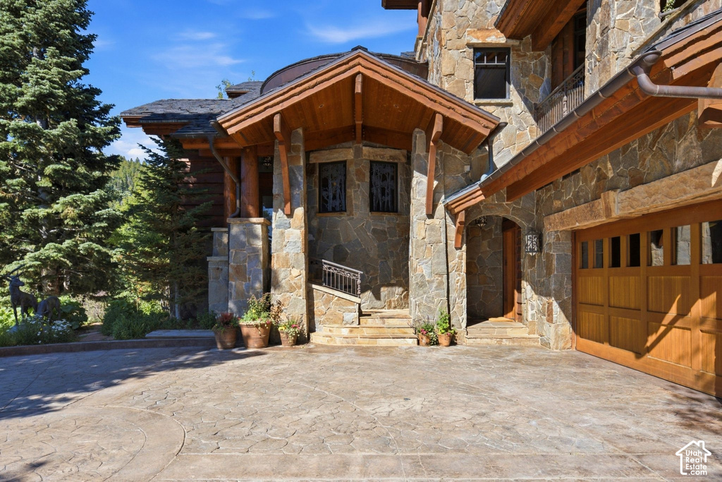 Stone facade residence with a prominent gabled entry featuring exposed wood beams and columns