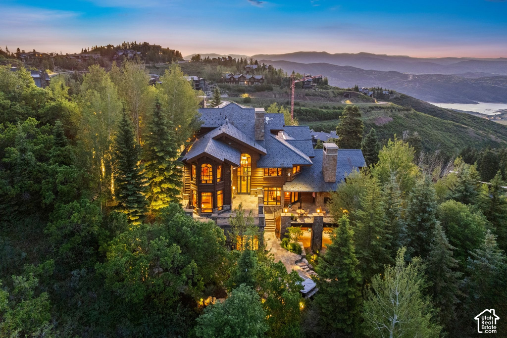Multi-level property featuring extensive stonework, wood siding, and multiple balconies
