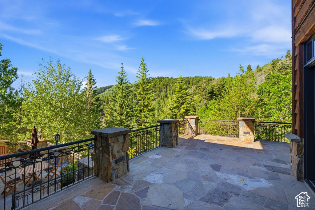 Expansive flagstone patio with wrought iron railings and stone pillars