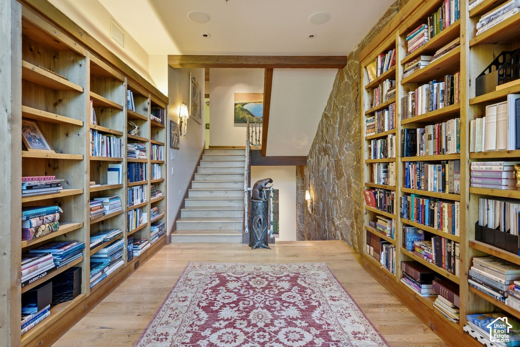 Extensive built-in wood shelving units flank a wood-finish flooring area with a centrally placed area rug