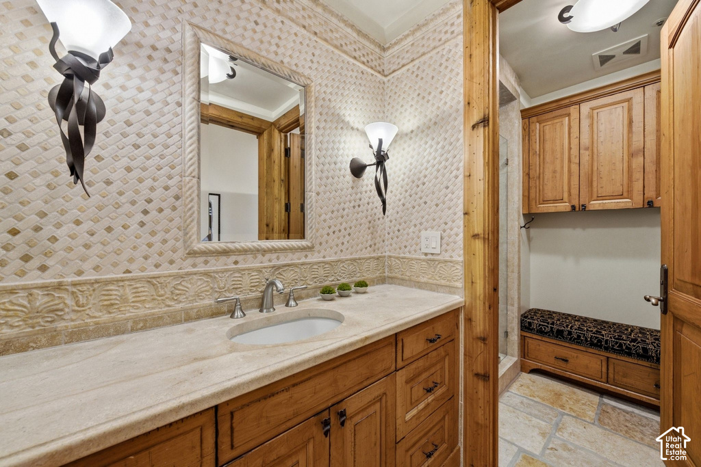 Bathroom featuring a custom wood vanity with a stone countertop and integrated sink