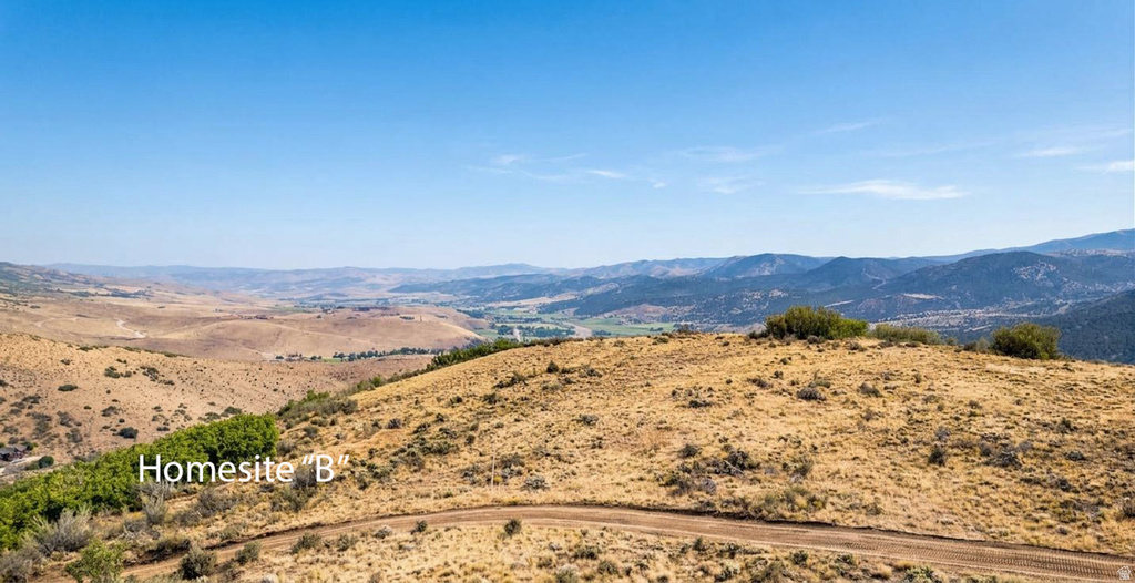 Expansive undeveloped terrain featuring rolling hills and distant mountain ranges