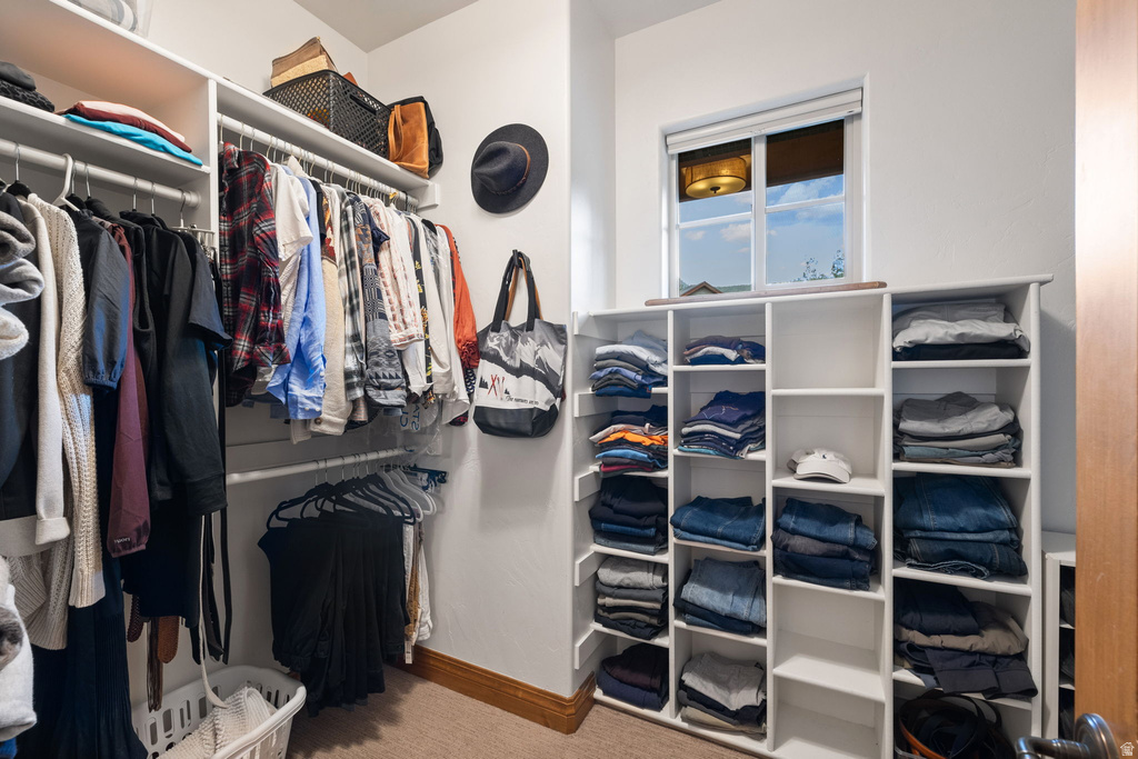 Walk-in closet featuring extensive built-in shelving and hanging racks