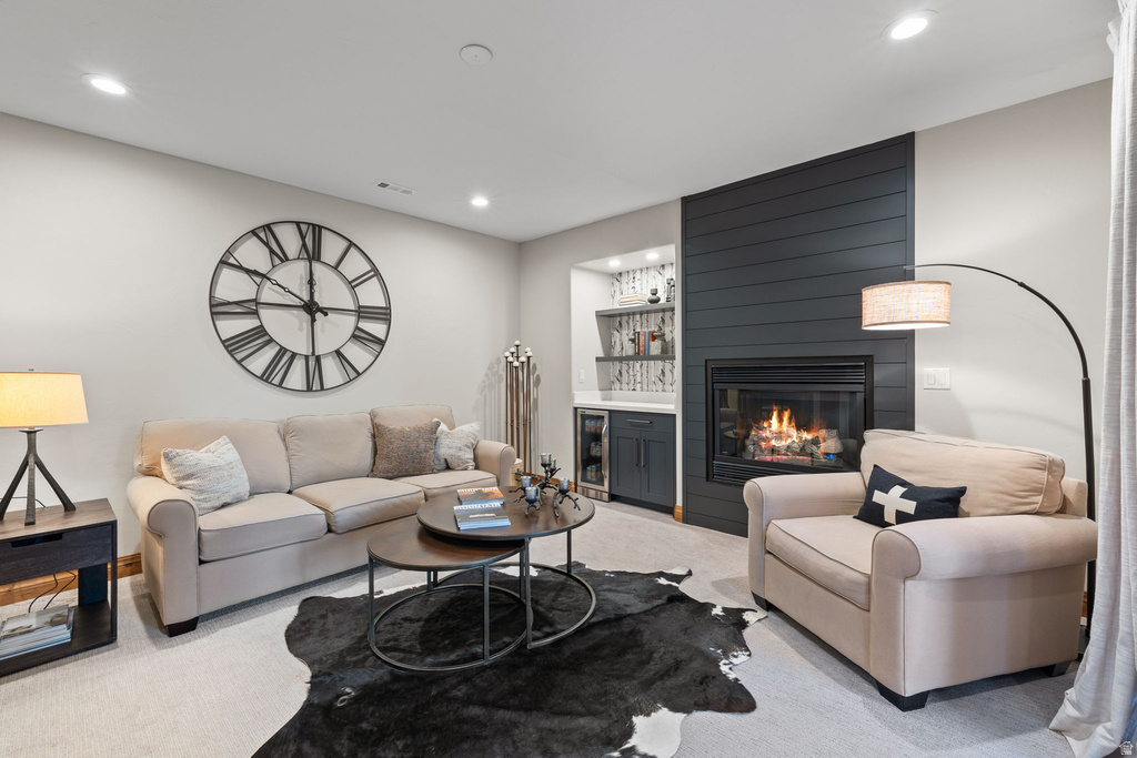 Living area featuring a shiplap accent wall with a built-in fireplace, recessed lighting, and a wet bar with integrated shelving