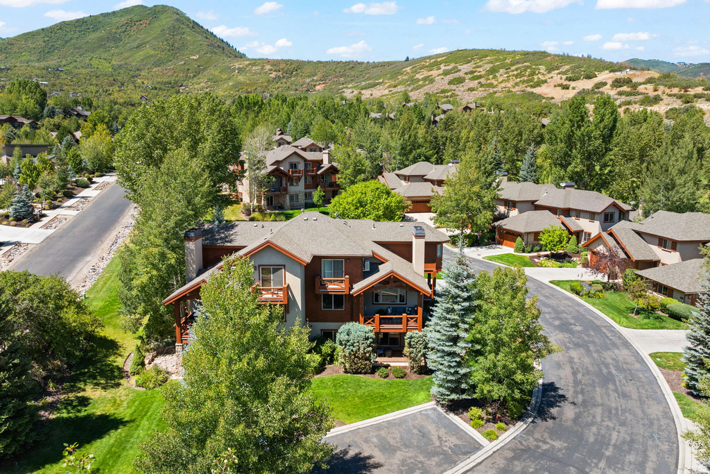 Architectural property featuring multiple balconies, a covered porch, and extensive landscaping