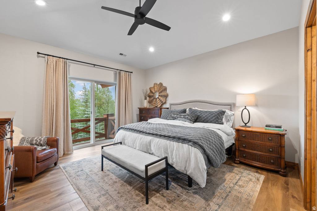 Spacious bedroom featuring light wood-finish flooring, recessed lighting, and a modern ceiling fan