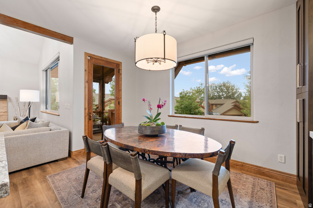 Dining area featuring a wood-finish oval table with a unique textured surface, illuminated by a drum pendant light fixture