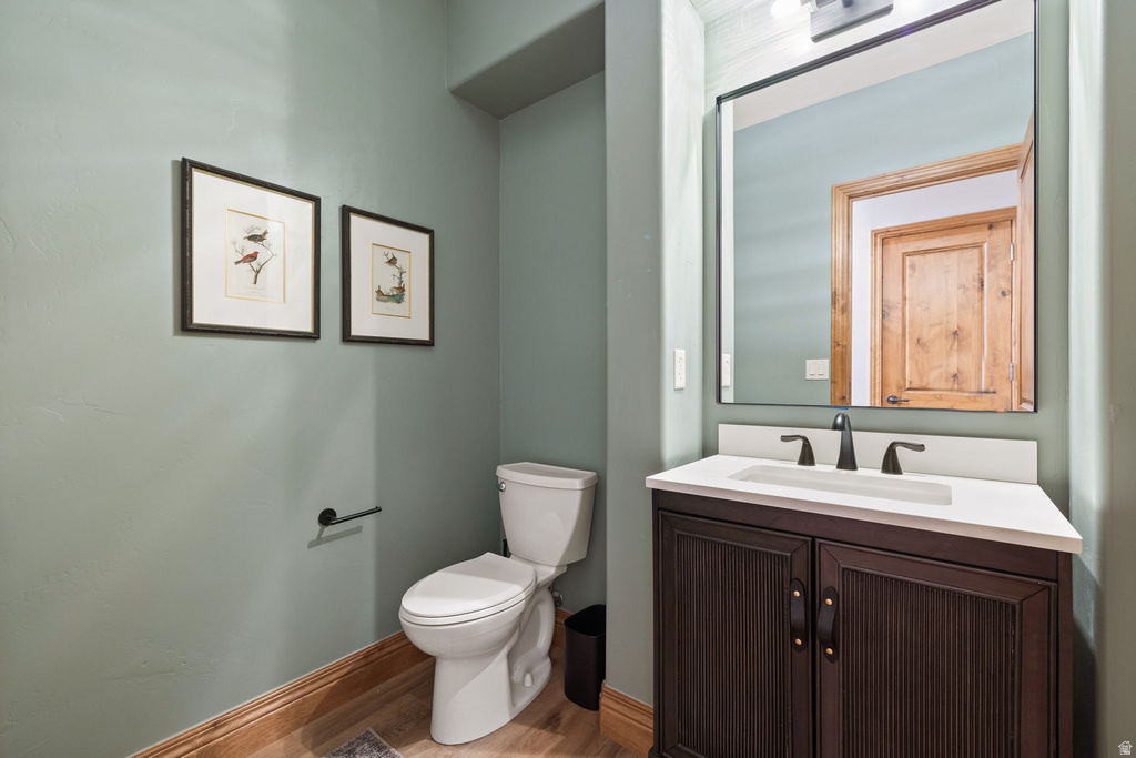 Powder room featuring a dark wood-finish vanity with a white countertop, undermount sink, and matte black fixtures