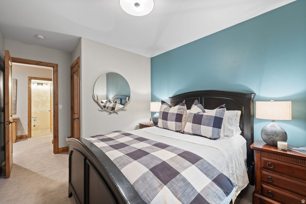 Carpeted room with a blue accent wall and a dark wood bed frame