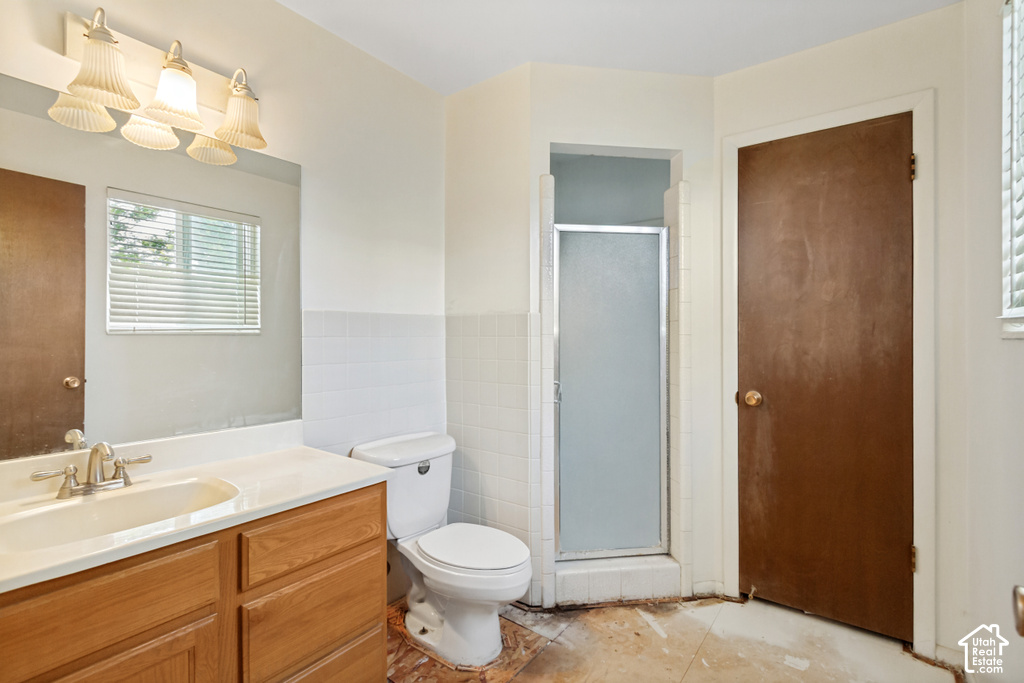 Bathroom featuring a wood-finish vanity with a built-in sink, a wall-mounted mirror, and a three-light fixture