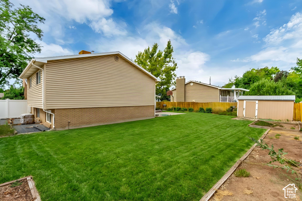 Expansive backyard featuring a manicured lawn, a detached storage shed, and a privacy fence