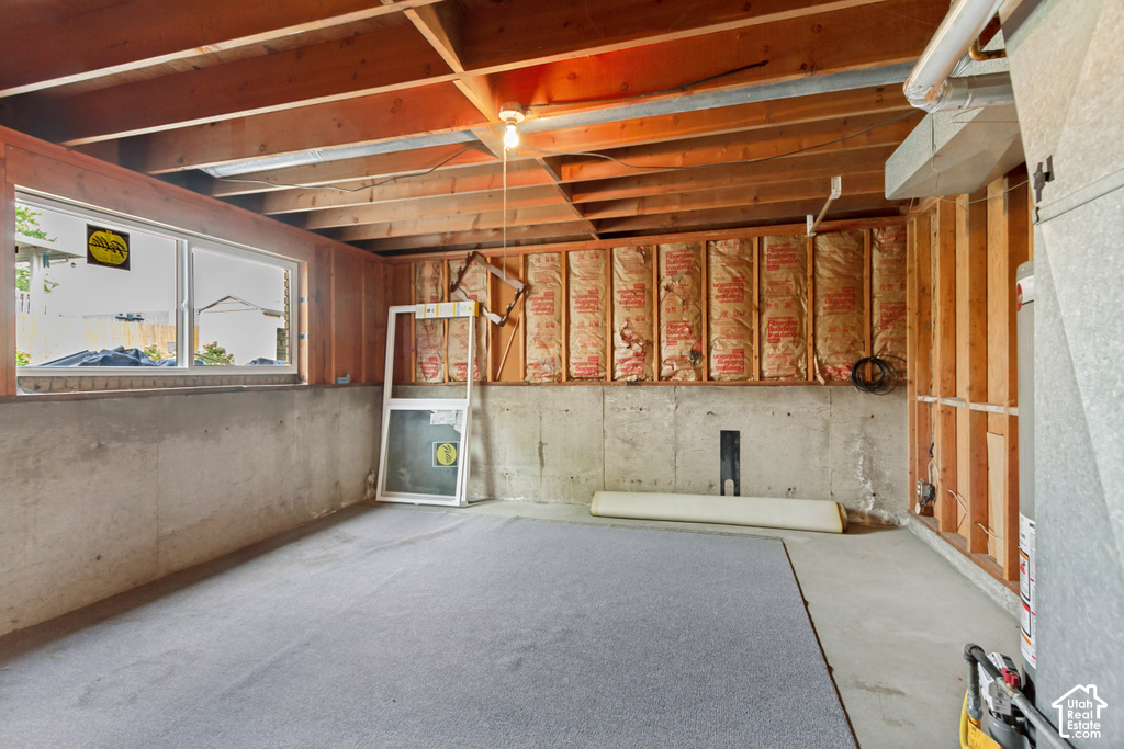 Unfinished basement space featuring exposed wood joists and structural framing