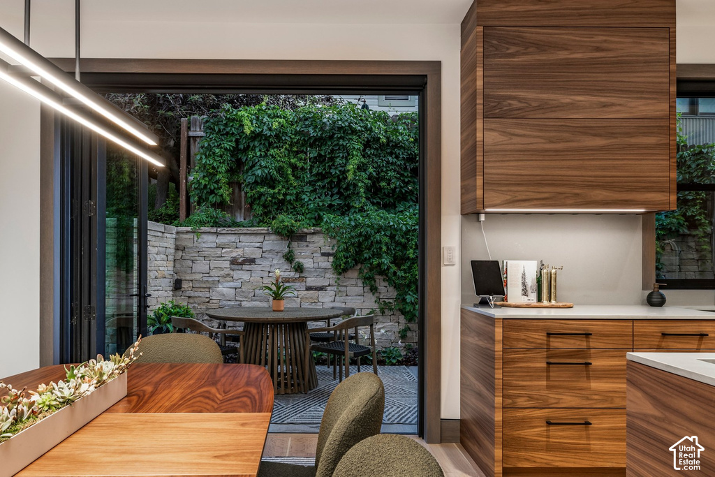 Expansive outdoor patio featuring a stone retaining wall with lush greenery