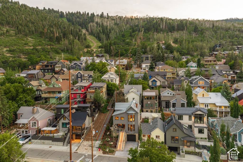 Residential area featuring a diverse collection of homes nestled into a green, tree-covered hillside