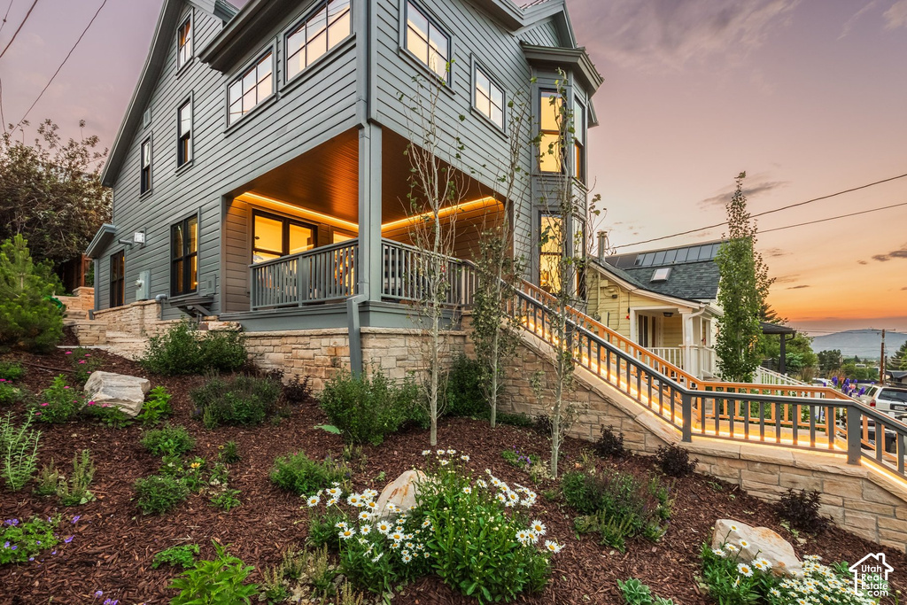 Multi-level exterior featuring gray horizontal siding and a covered porch with recessed lighting