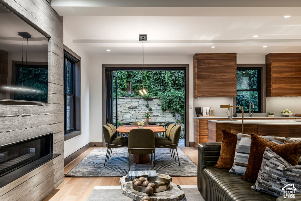 Open-concept living space featuring light wood-finish flooring, a contemporary fireplace with a concrete-effect surround, and an integrated television