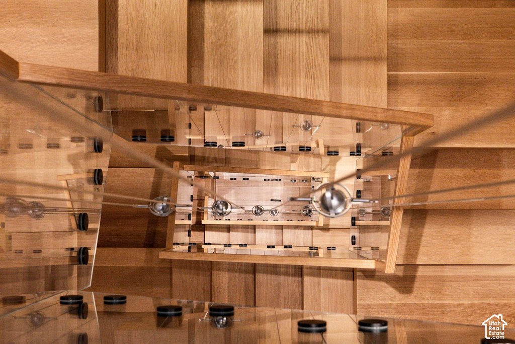 Modern staircase featuring wood-finish treads and risers, glass balustrade panels, and stainless steel cable railing