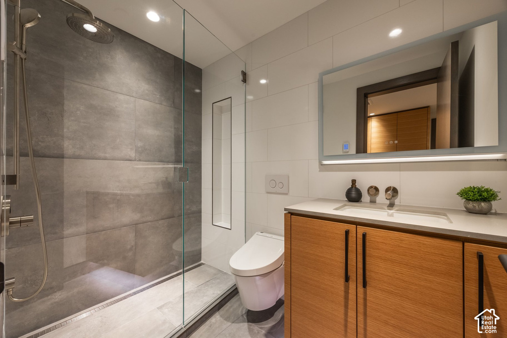 Contemporary bathroom featuring a glass-enclosed shower with large format gray wall tiles and an integrated niche