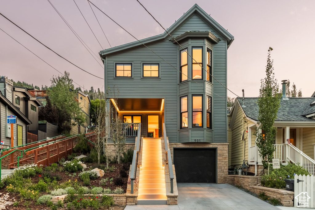 Contemporary multi-level residence featuring a gray exterior siding and a prominent bay window with black trim