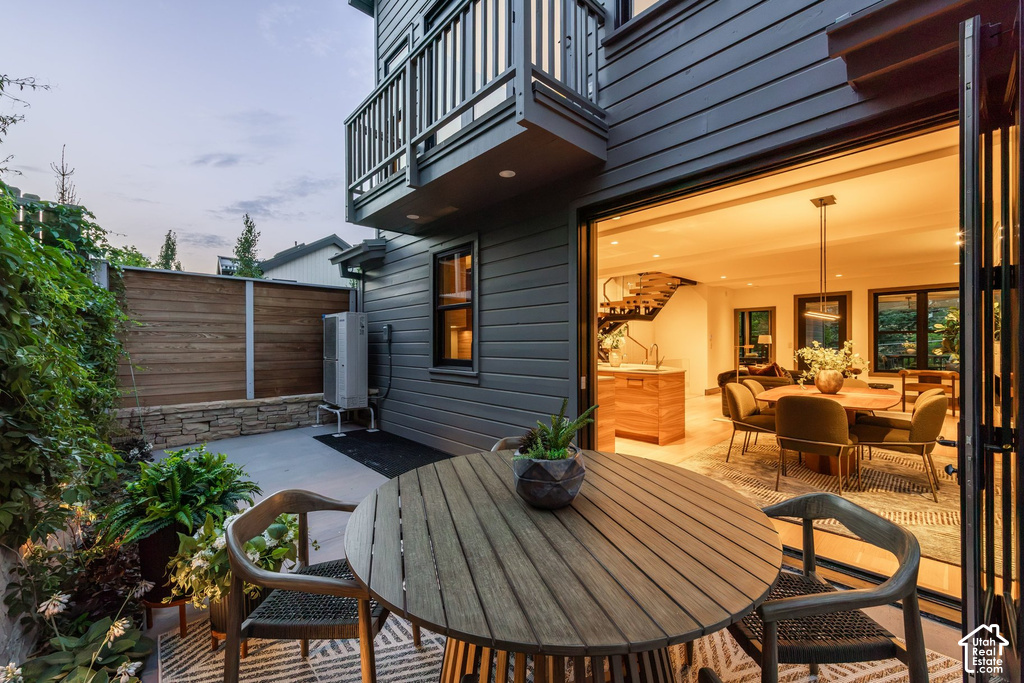 Outdoor patio with concrete hardscaping, bordered by a stone wall and wood-finish fencing