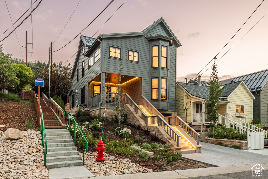 Multi-level residence featuring a gray exterior with a bay window and dark trim