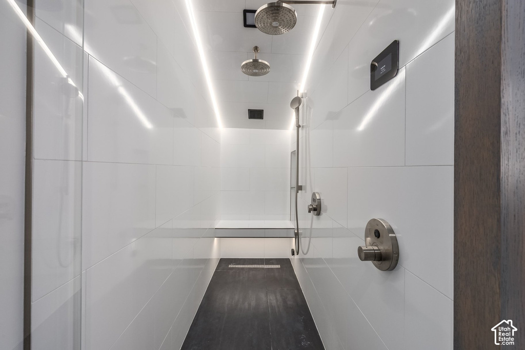 Contemporary walk-in shower featuring multiple shower heads, a built-in bench, and integrated LED lighting