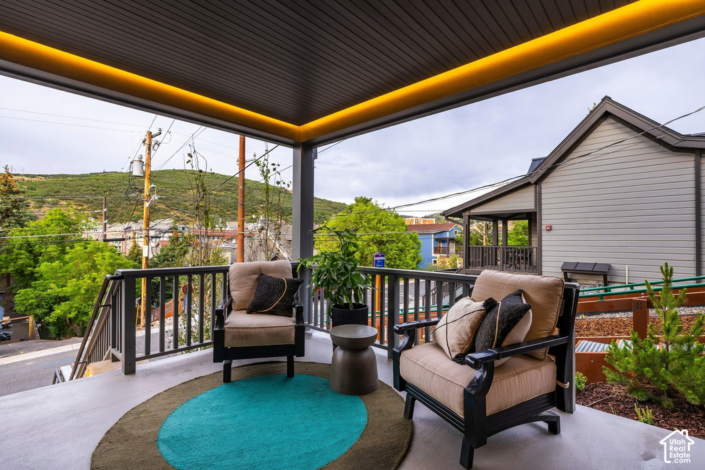 Covered outdoor patio featuring recessed ceiling lighting, slatted railing, and mountain scenery