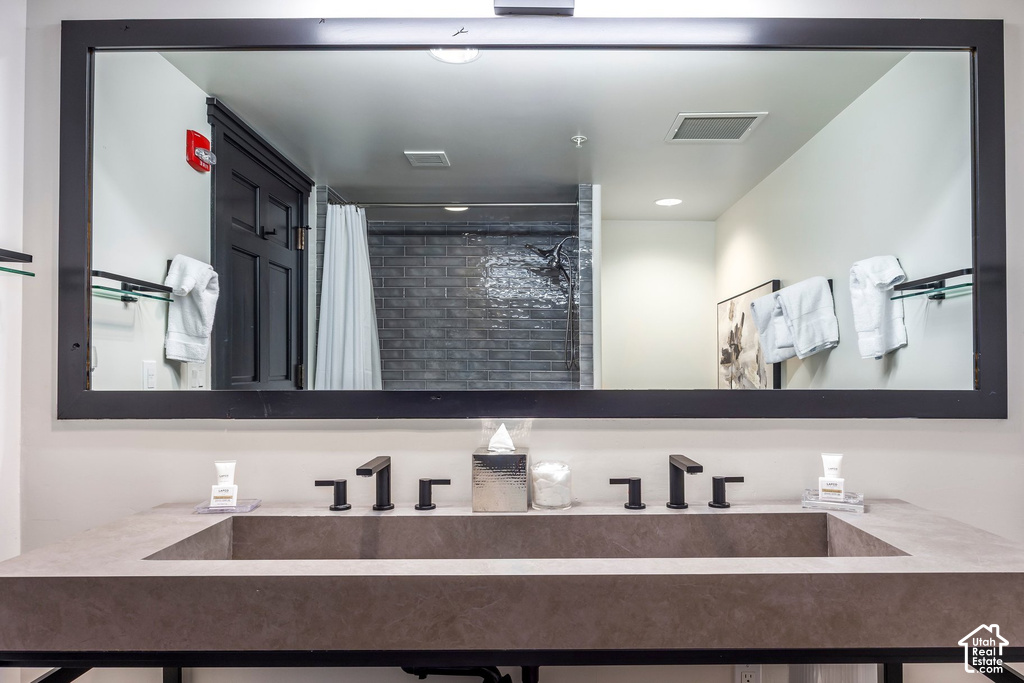 Double vanity featuring integrated rectangular sinks, matte black fixtures, and a large black-framed mirror