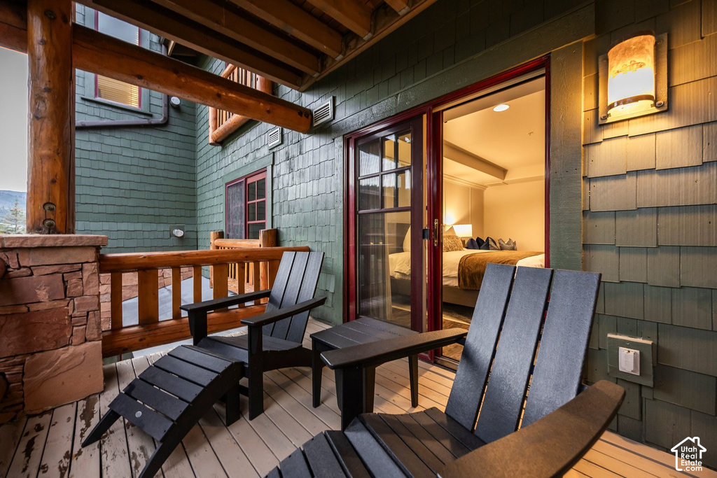 Outdoor balcony featuring wood-finish decking and stone pillar