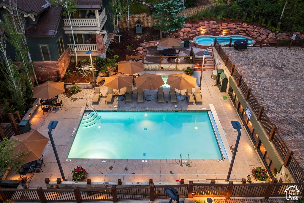Outdoor recreation area featuring a rectangular swimming pool, an elevated spa, and a surrounding concrete patio