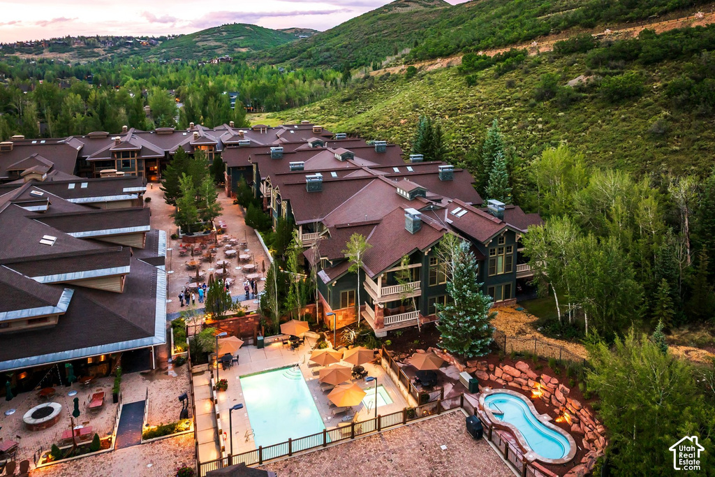 Expansive property featuring multiple buildings with dark brown roofs, an outdoor swimming pool, and a separate hot tub