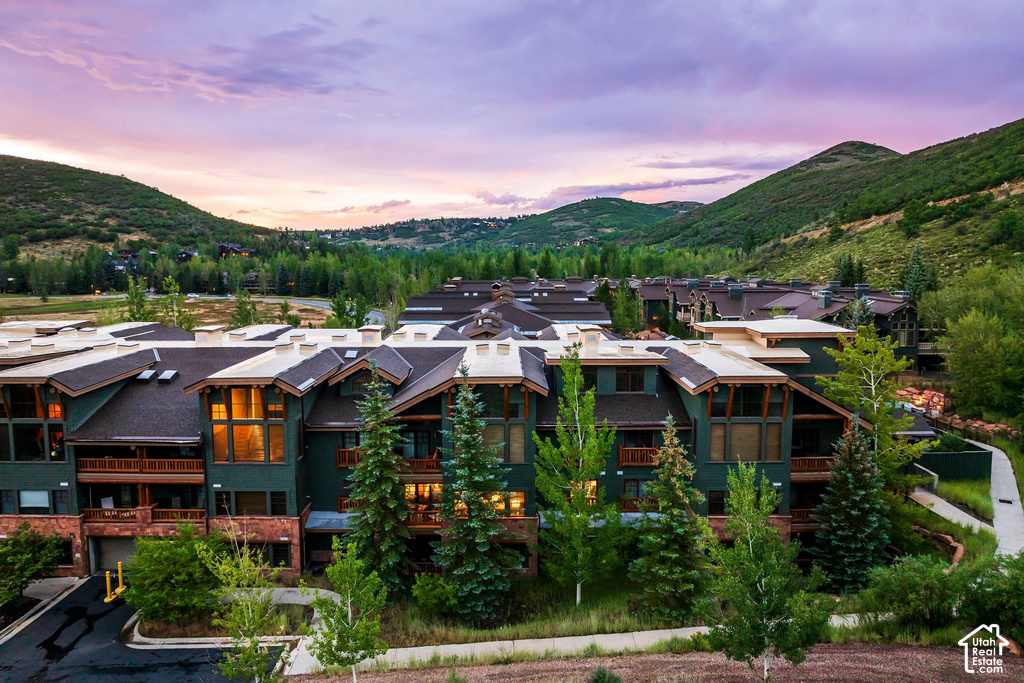 Modern mountain-style complex featuring multiple balconies, large picture windows, and covered parking