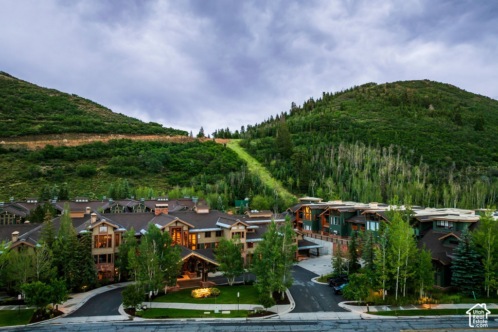 Mountain-facing property with multi-level structures, featuring prominent gabled roofs and visible residential units