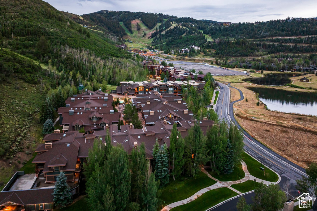 Mountain resort community featuring multi-story buildings with brown roofs, extensive landscaping, and paved roadways