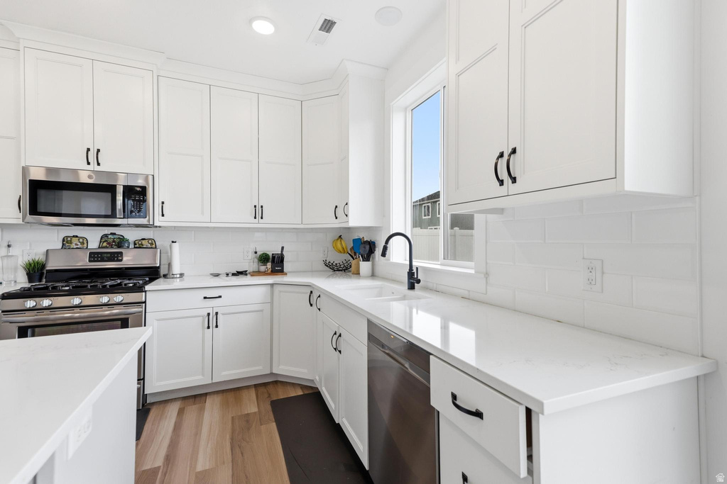 White shaker cabinetry paired with light-toned countertops and a matching subway tile backsplash