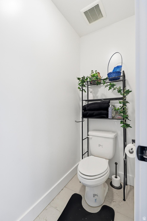 White toilet with a white tank in a compact space