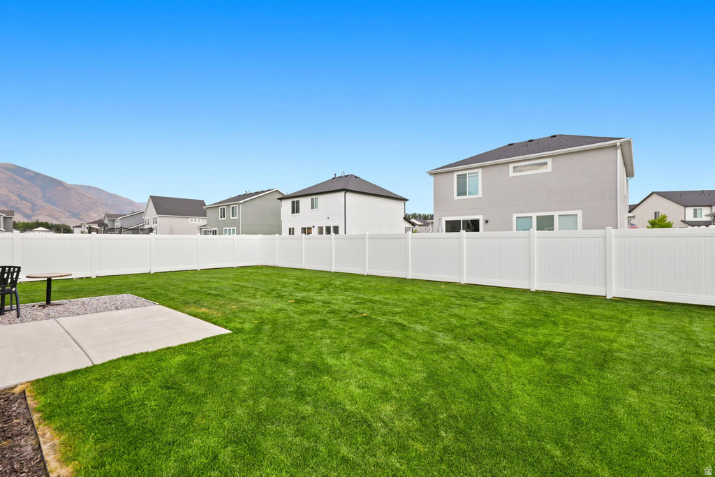 Expansive green lawn with a white privacy fence