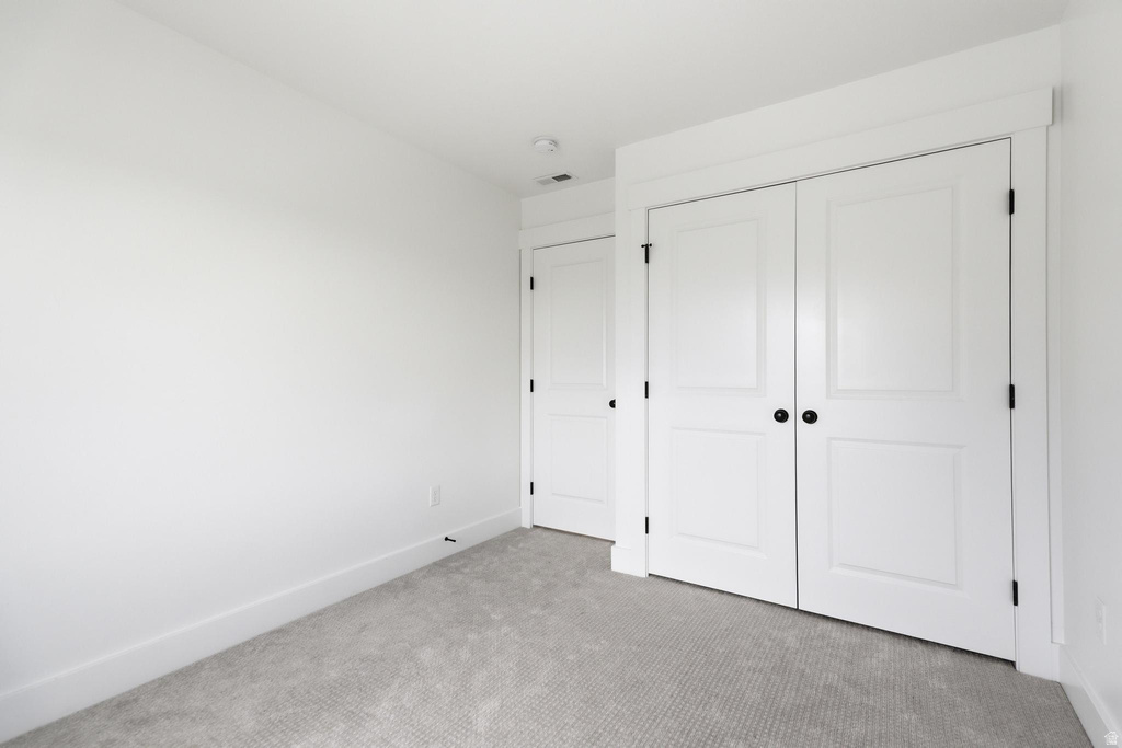 Room featuring neutral gray carpet, white painted walls, white baseboards, and a white ceiling