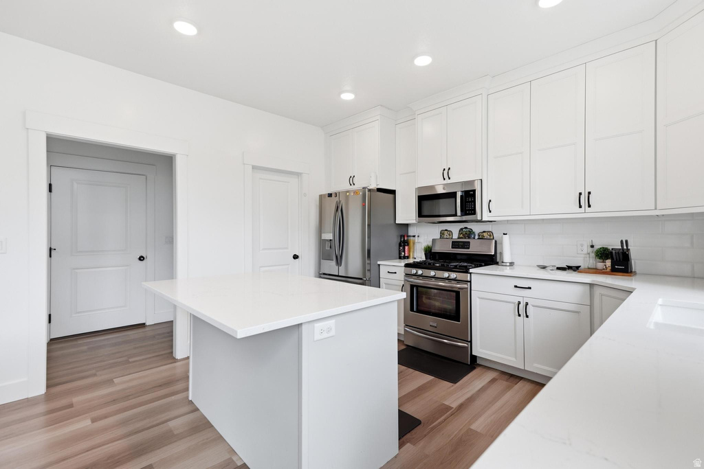Modern kitchen featuring a central island with a white countertop