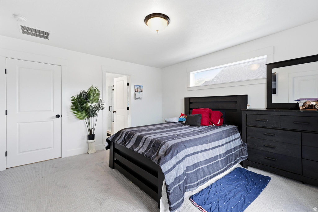 Bright interior room featuring white walls, light-colored carpet flooring, a transom window, and a flush mount ceiling light