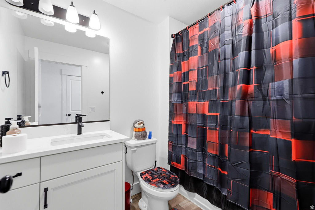Bathroom featuring a single vanity with an integrated sink, white countertop, and dark-finish faucet