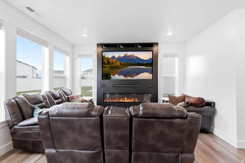 Living area featuring a floor-to-ceiling media wall with an integrated electric fireplace and a large television display