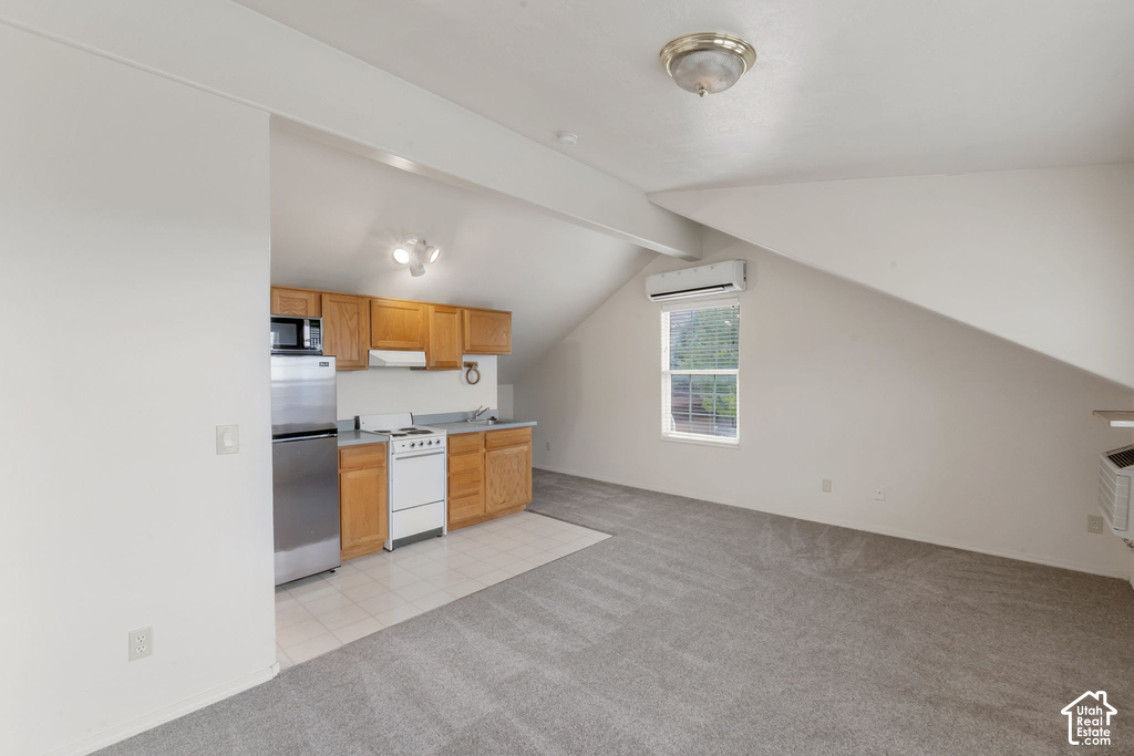 Compact kitchen featuring wood-finish cabinetry, stainless steel refrigerator, and built-in microwave