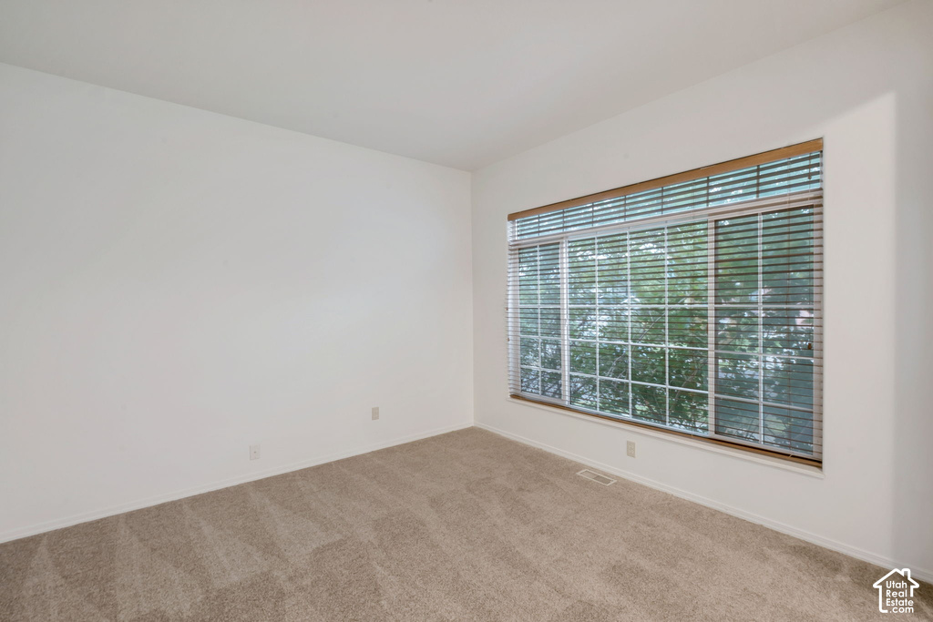 Expansive window with horizontal blinds and wood-finish valance, offering natural light