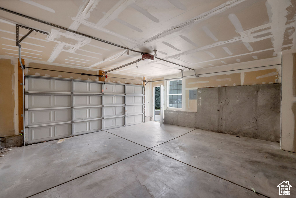 Concrete flooring with expansion joints, two garage doors, and a window for natural light