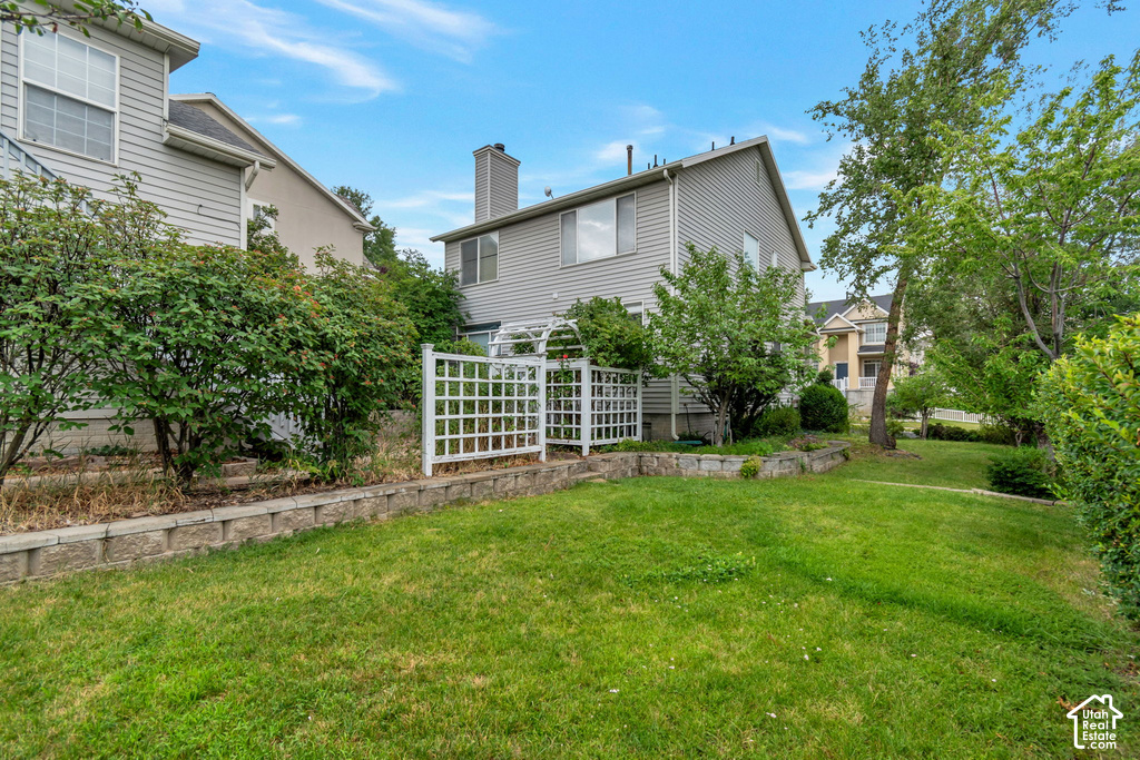 Expansive green lawn with mature trees and established perimeter shrubs