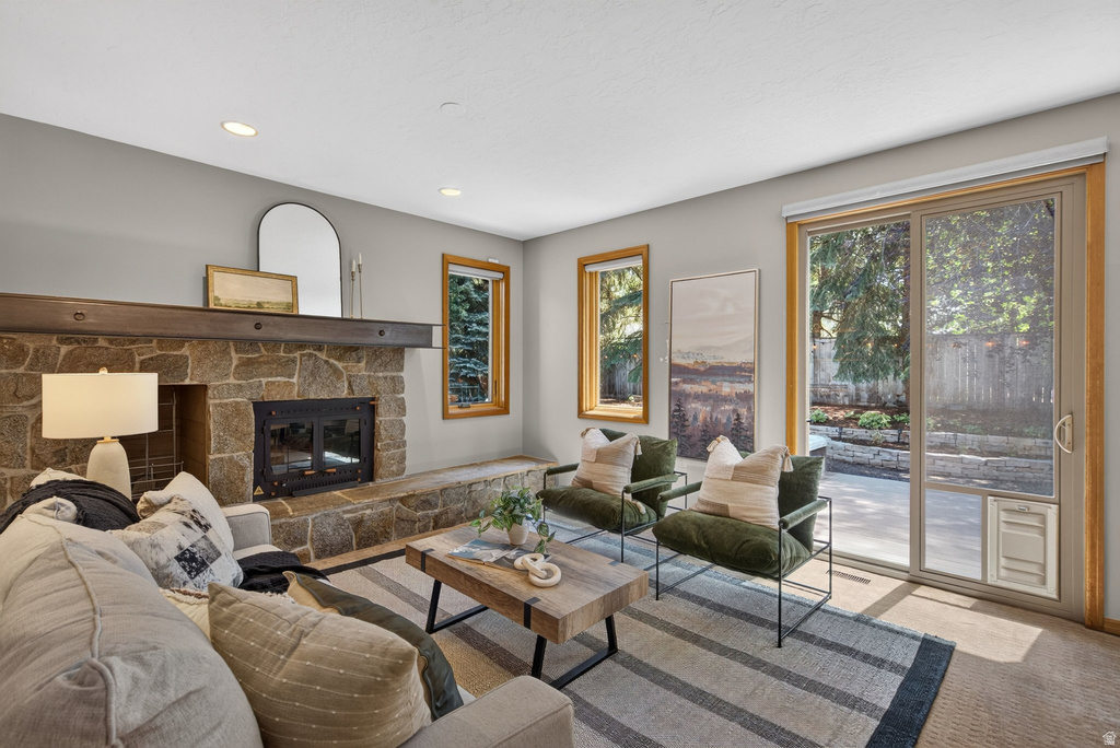 Stone fireplace with wood mantel, adjacent to large sliding glass doors providing access to an exterior patio