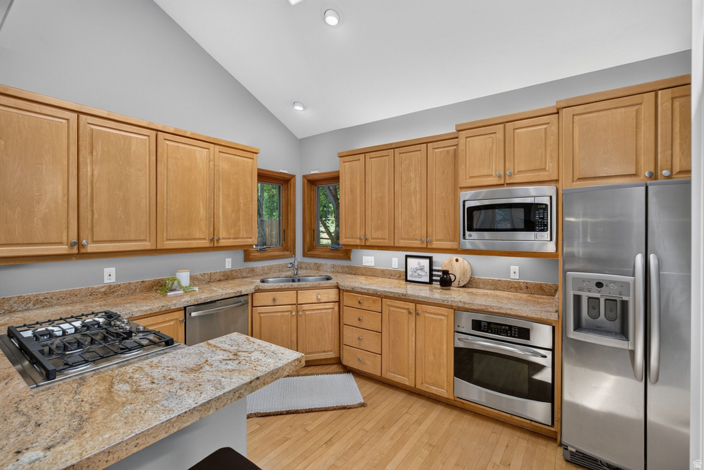 Kitchen featuring wood cabinetry, stainless steel appliances, a gas cooktop, a built-in oven, and wood-finish flooring