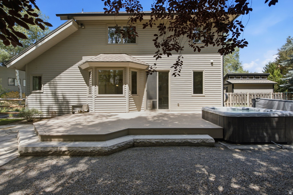 Rear exterior featuring a multi-level deck, integrated hot tub, and a bay window