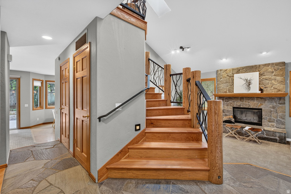 Entryway featuring flagstone flooring, wood-paneled doors, and a custom wood staircase with decorative wrought iron railing